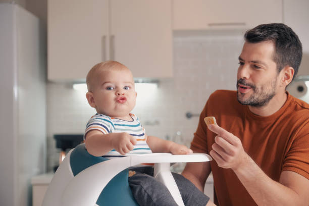 istock handsome young father feeding his son 1353163328