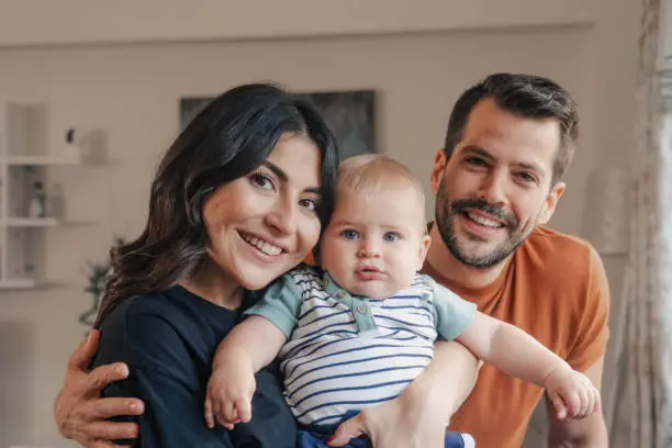 Photo of portrait of young family with toddler