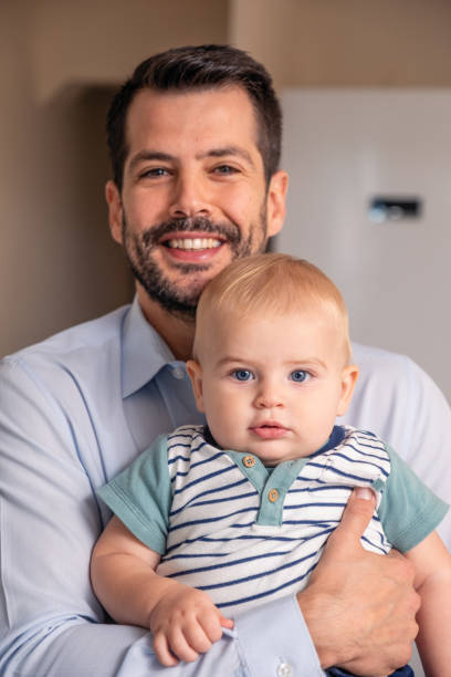 istock handsome young father and his cute son looking at camera 1353163360