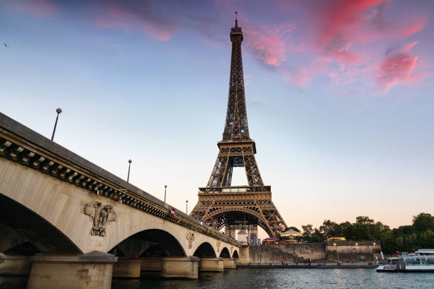 эйфелева башня париж мост сена река закат сумерки франция - dramatic sky built structure tower monument стоковые фото и изображения