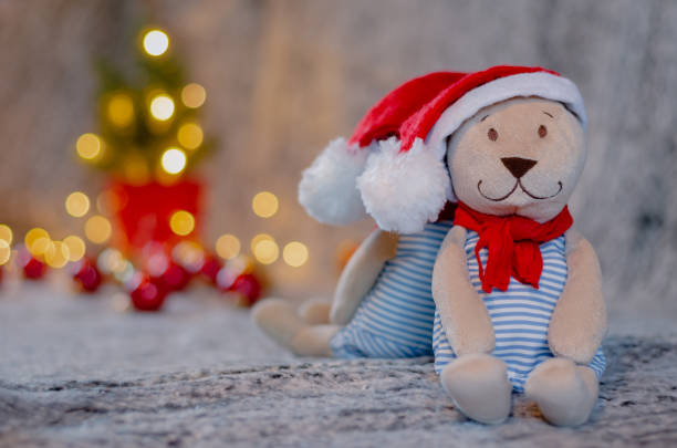 istock Santa teddy bear doll with bokeh light background of Christmas tree 1353164403