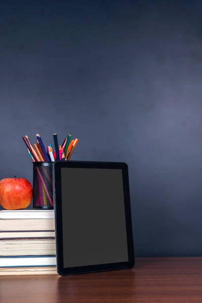 istock e-learning:Books and digital tablet on school desk with chalkboard 1353172415