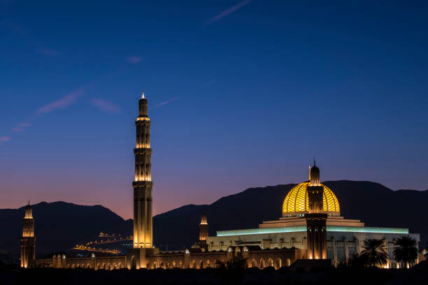 Sultan Qaboos Grand Mosque dome and minaret with illuminated garden shining at night, Muscat. Oman