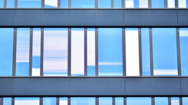istock Modern office building with glass facade on a clear sky background. 1353179628