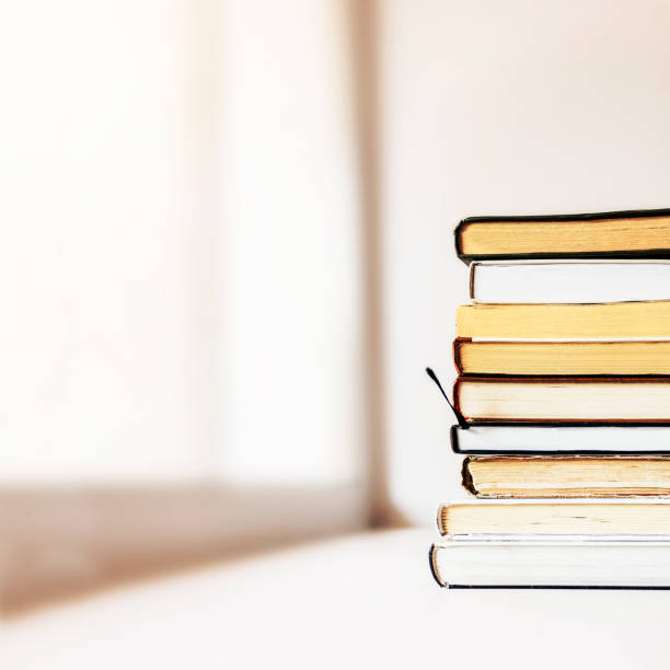 istock a stack of books by the window. Selective focus 1353180660