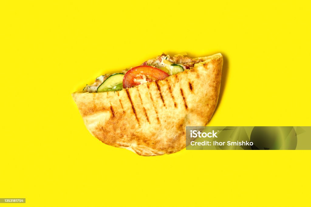 Top view of pita with chicken and vegetables on a yellow background. Shawarma with chicken Pita Bread Stock Photo