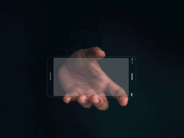 istock Futuristic transparent glass phone Technology. Super slim transparent future smartphone with horizontal mock-up blank screen in hand on dark background. 1353185837