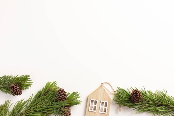 istock Christmas composition. Spruce branches with small wooden house, on a white background. Christmas, winter concept. Flat lay, top view. 1353187941