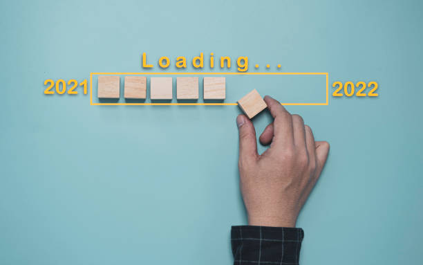 istock Businessman putting wooden cube block for loading progressive and countdown from 2021 to 2022 concept. 1353189580