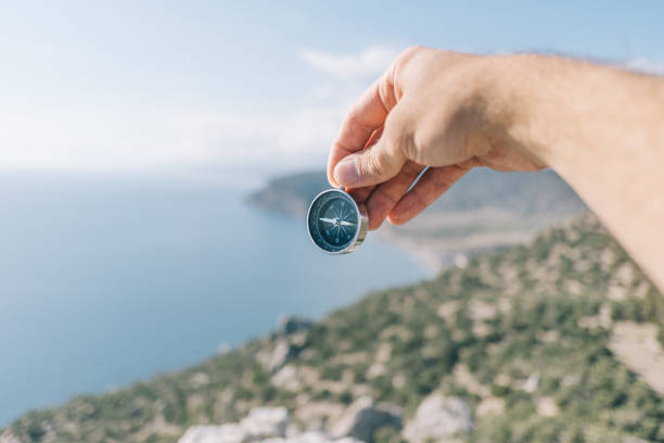 istock Compass in male hands in the background sea and mountains. 1353190858