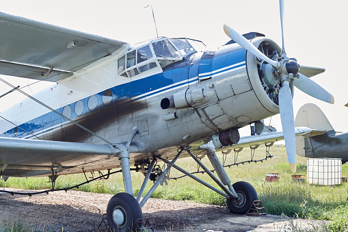 A Soviet-era aircraft in good condition is standing in a field.