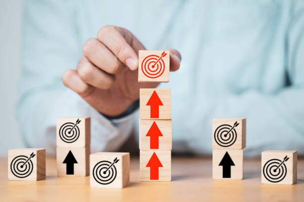 istock Businessman putting target board on up arrows which print screen on wooden cube block, increasing and challenge of setup business achievement objective target concept. 1353194352