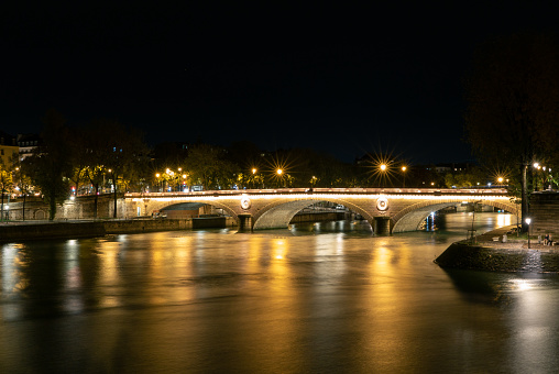 close up of the Pont Louis-Philippe bridge, which leads from the inland island Île Saint-Louis over the river Seine. long exposure which makes the water of the river soft and smooth. 10/30/2021 - Quai aux Fleurs near the bridge Pont d’Arcole, 4th arrondissement, 75004 Paris, France