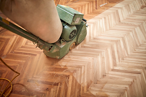 Restoring parquet with a sanding machine.