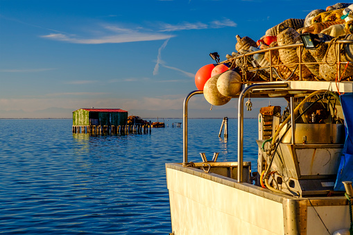 Pellestrina island, Venetian lagoon, Italy - 22 november 2020: View on the Venetian lagoon with the boat and fishermen's houses