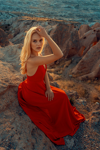 Portrait of young woman with blond hair in a red dress.