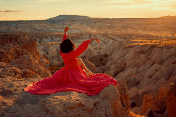 istock young woman dancing sitting down at sunset. 1353206705