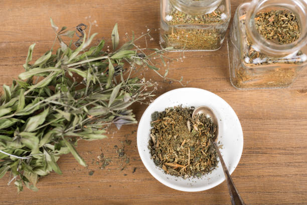istock Herbal tea and dried herbs or medicine in jars with spoon 1353211952