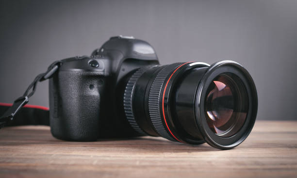 istock Professional DSLR camera on the wooden table. 1353213674