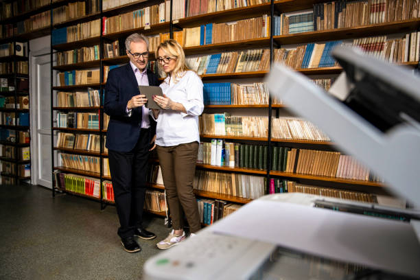 istock Teachers use tablets to search for a book in the school library 1353218595