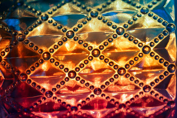 Blurred texture of transparent illuminated glass. Bright light orange background