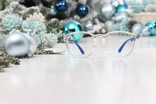 christmas eyeglasses blue spectacles isolated on white table with balls and decorations useful as a greeting gift card template with copy space