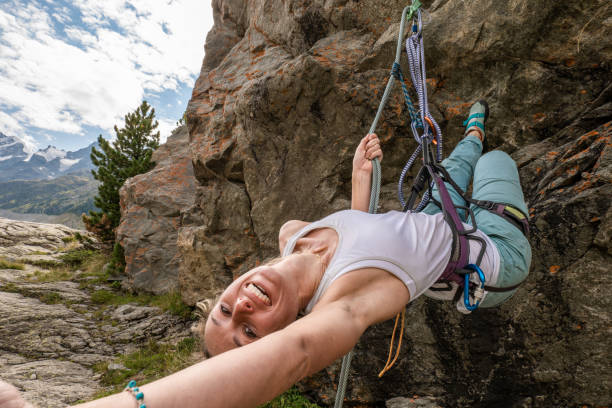 alpiniste sur une paroi rocheuse prenant un selfie - mountain climbing rock climbing motivation awe photos et images de collection