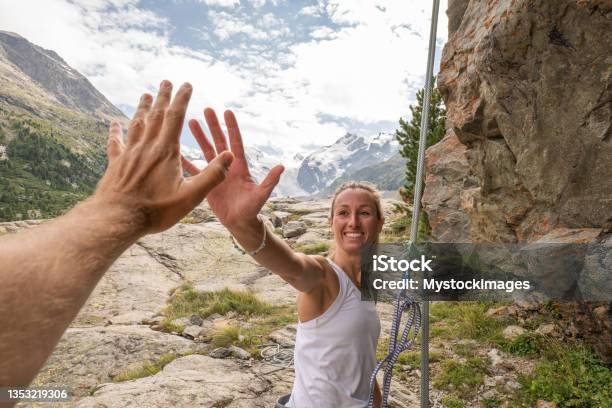 Mountain Climber High Fives With Partner At The Top Of The Rock Stock Photo - Download Image Now