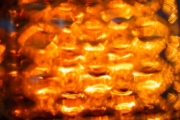istock Blurred texture of transparent illuminated glass. Bright light orange background with blur 1353219688