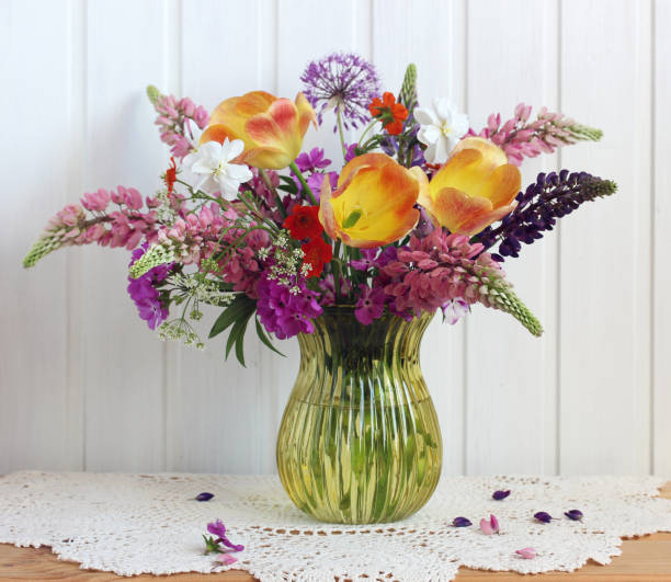 istock tulips lupines and daffodils in a glass vase 1353219796