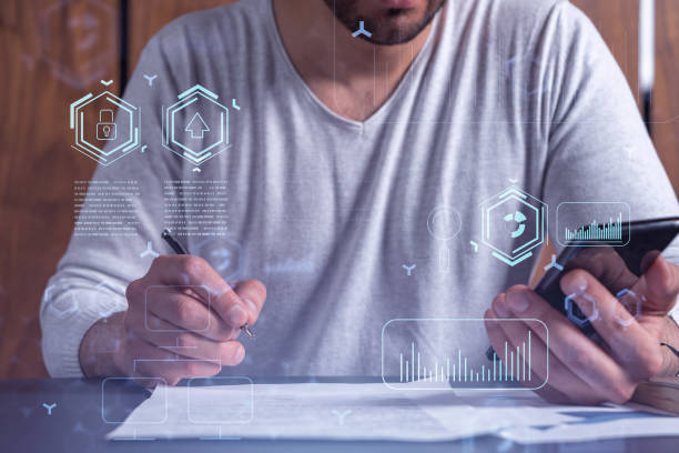 istock A client is signing the contract to create a software to present it at start up conference and gain investments for innovative service. Checking the details at smartphone. Hologram tech graphs. 1353222477