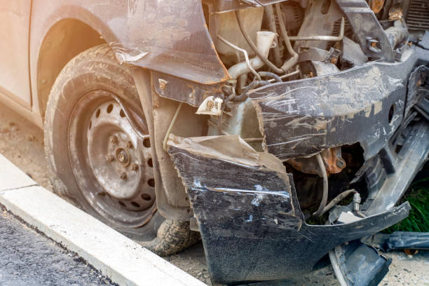 istock Close up view of black car getting an accident with broken bumper. Crashed vehicle after accident on road in city. 1353224013