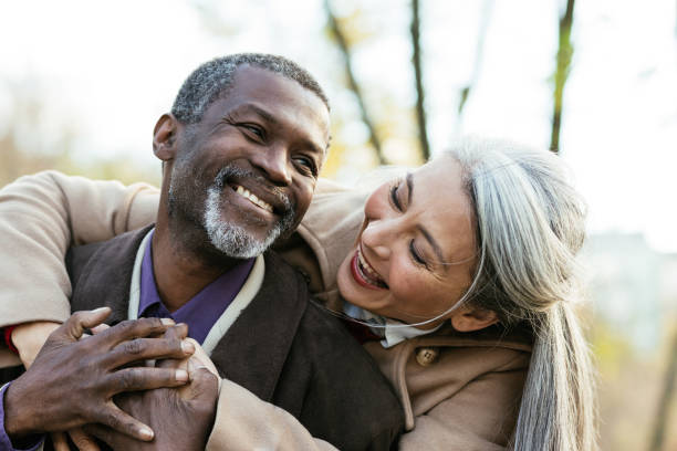 opowiadający historię obraz zakochanej wieloetnicznej pary seniorów - embracing heterosexual couple men women zdjęcia i obrazy z banku zdjęć