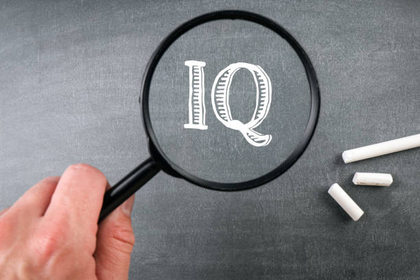 istock IQ Test. Challenge, knowledge and understanding concept. Magnifying glass and chalk board 1353224890