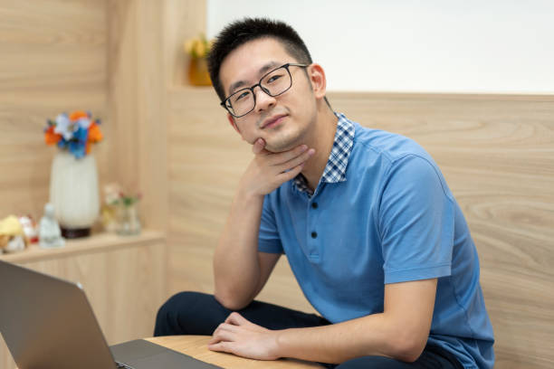 istock Asian man working at home with laptop and thinking 1353225322