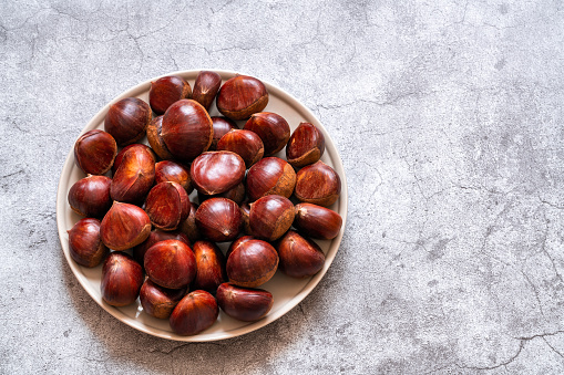 Fresh sweet chestnuts. Roasted chestnuts. Cement background