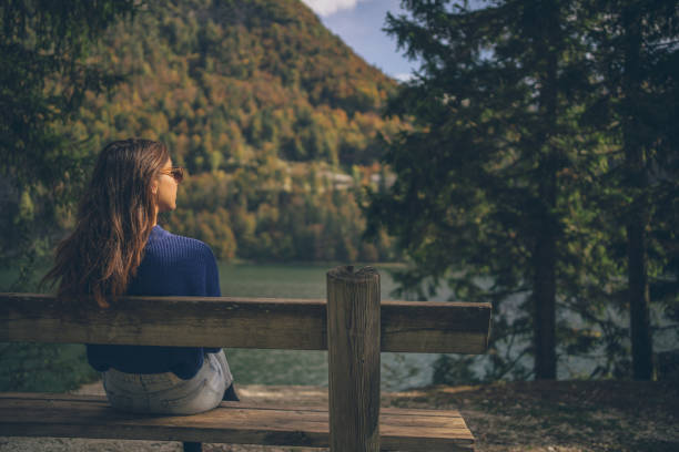 She looks out to distant scene, in the forested European Alps