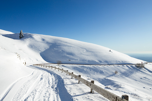 Winter landscape, curves road with snow. Mount Grappa landscape, Italy