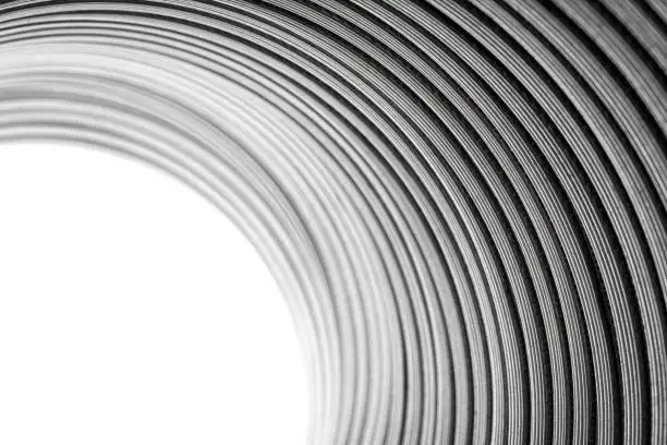 Flexible corrugated aluminum tube seen from the inside, resistant to high temperatures, isolated on a white background, selective focus.
