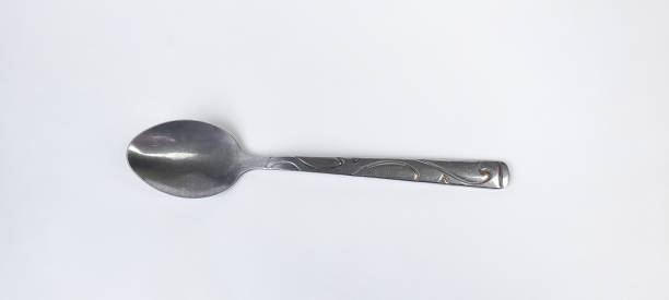 istock Small iron spoon with engraving on the stem isolated on white background. 1353232598