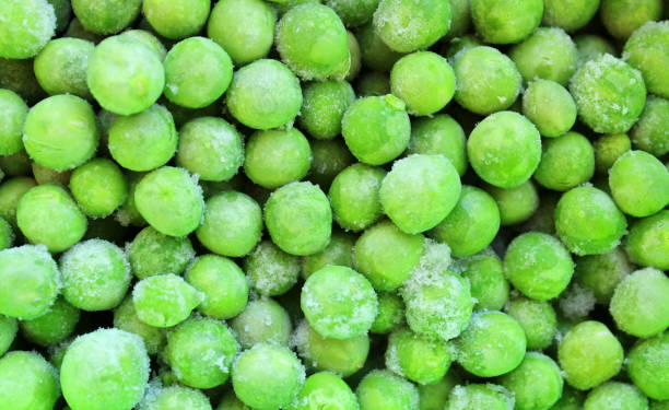 istock Frozen green peas, vegetables background 1353232976