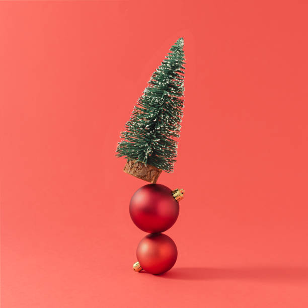 istock Creative composition made with Christmas tree and ornaments against red background. Minimal New Year celebration concept. 1353235451