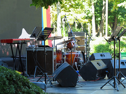 Concert stage: musical instruments, drums, amplifiers, speakers, microphones, cables.