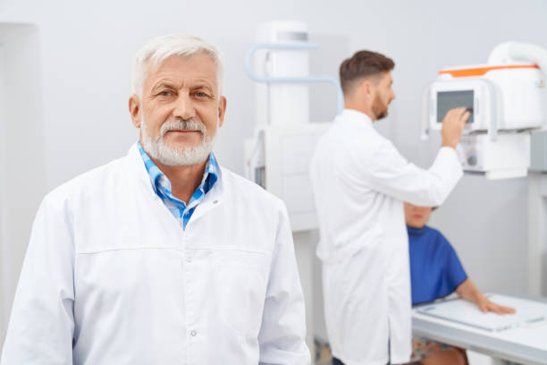 istock Old beard doctor and assistant working with ultrasound. 1353236546