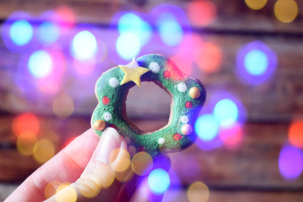 istock Hand holding wreath shaped Christmas cookie 1353238441