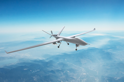 Unmanned spy military drone flies over mountains at day time
