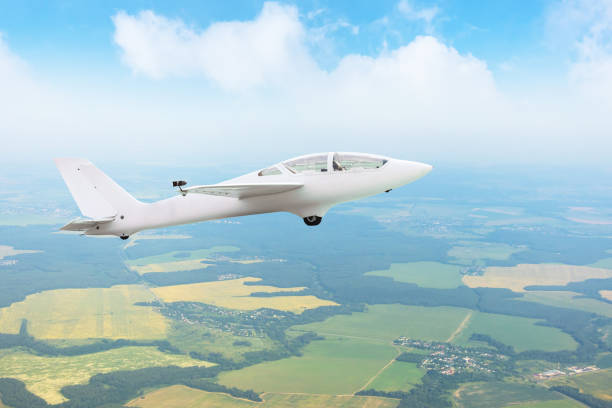istock Glider flying high in the sky over fields and forests, aerial view. 1353241161