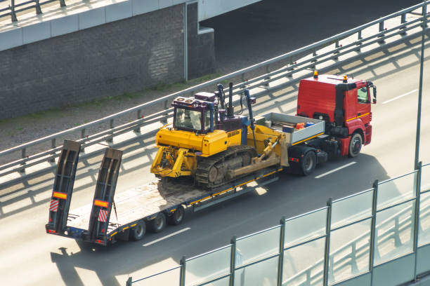 a large truck transporting a bulldozer on its flatbed