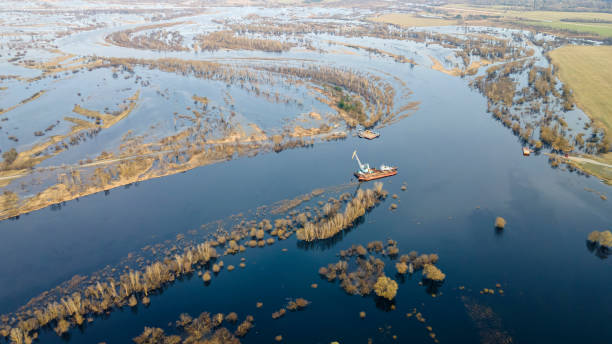 istock Floating crane on the river. Dredging crane working near shore. Conservation river flow. Nature, river, sky, clouds. 1353243917
