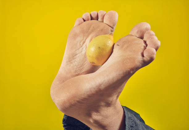 Man holding lemon with his feet